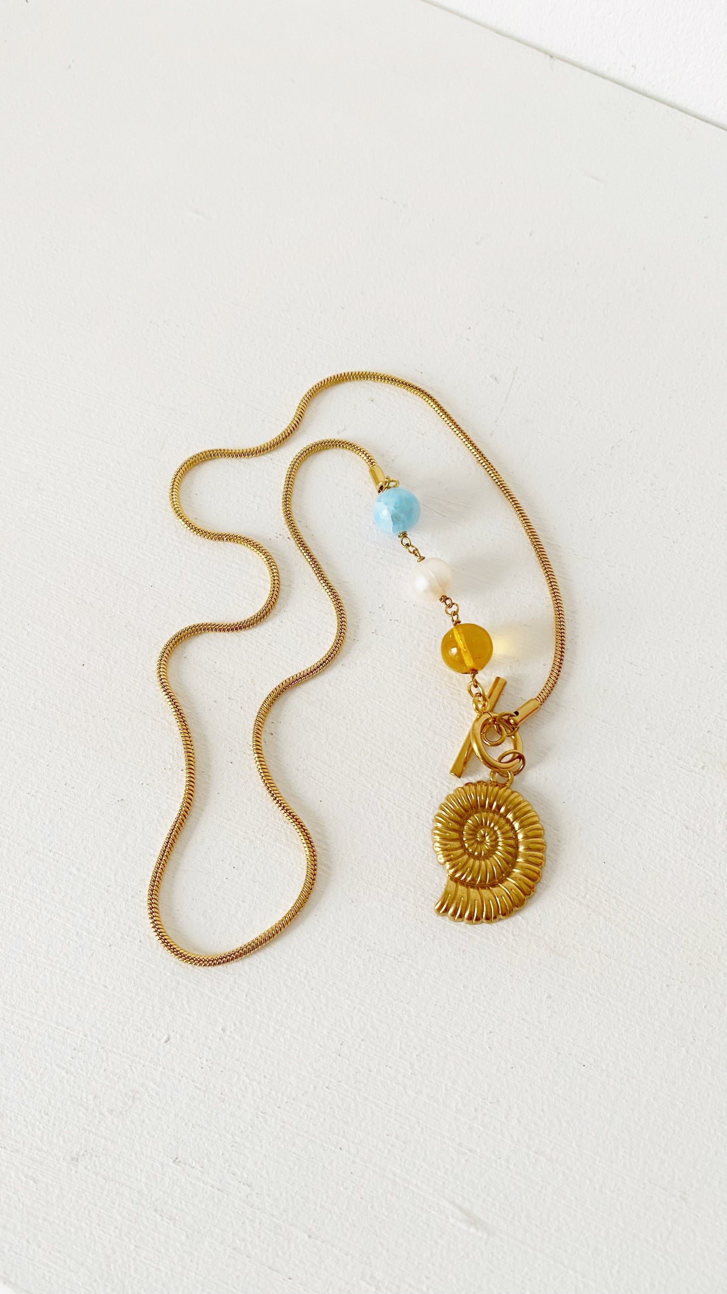 Cadena con caracol y larimar, ámbar y perla de rio