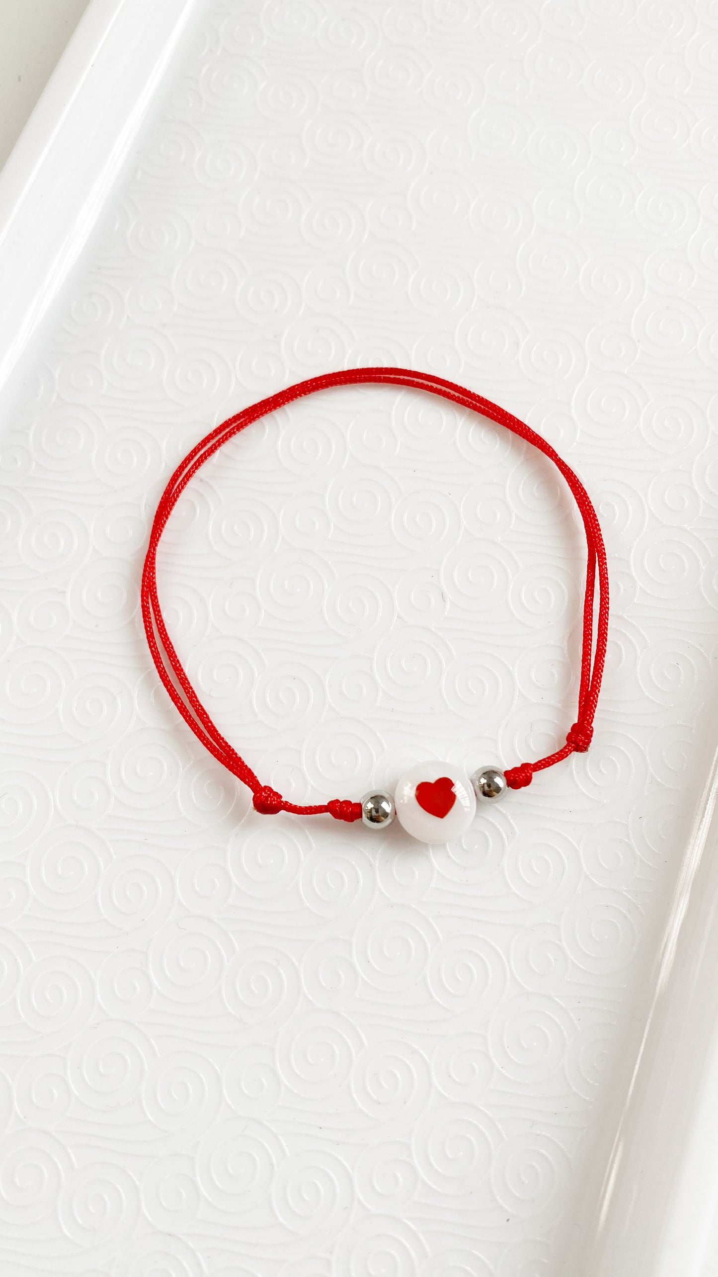 Pulsera de hilo con corazón rojo en nácar