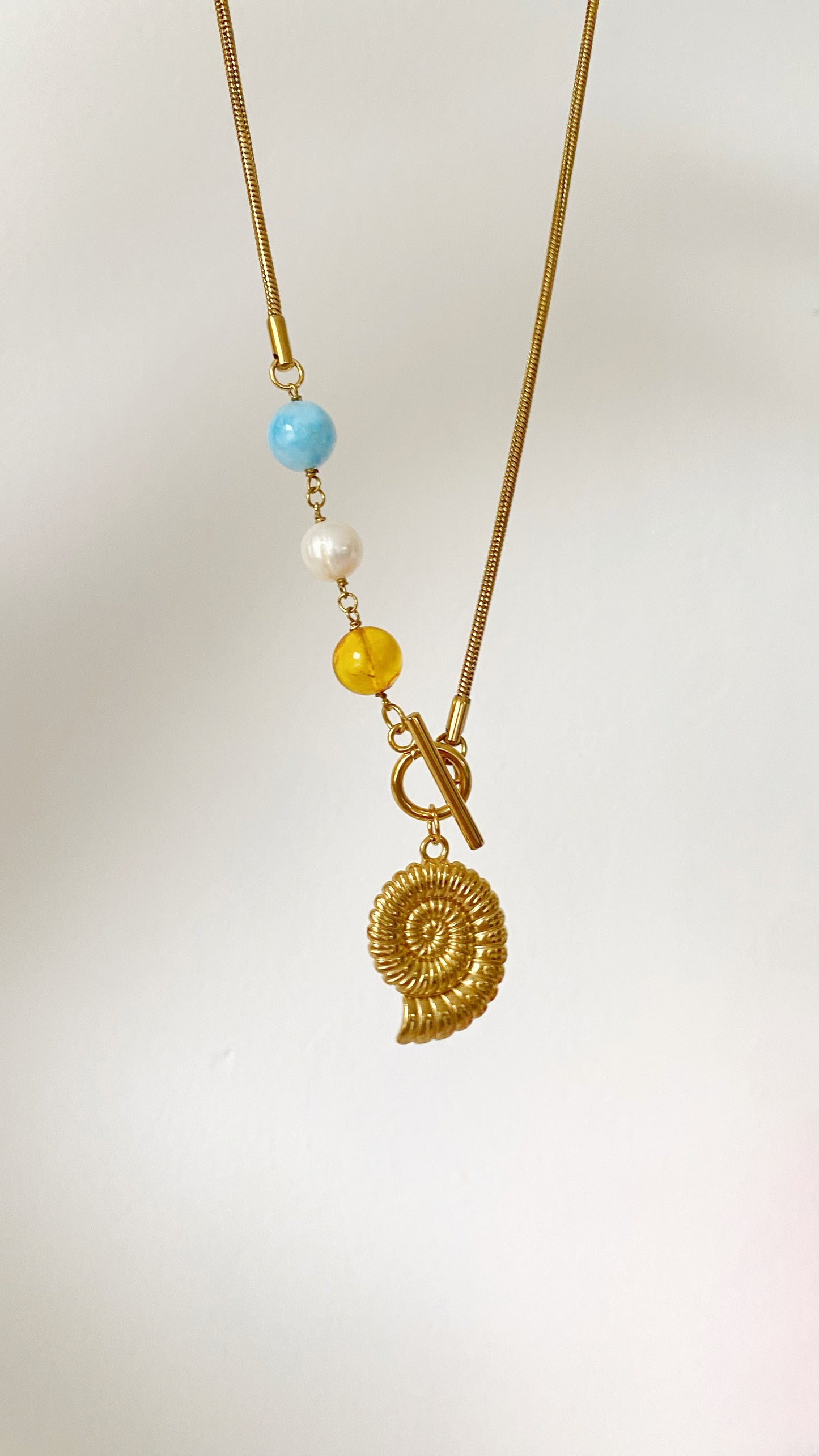 Cadena con caracol y larimar, ámbar y perla de rio
