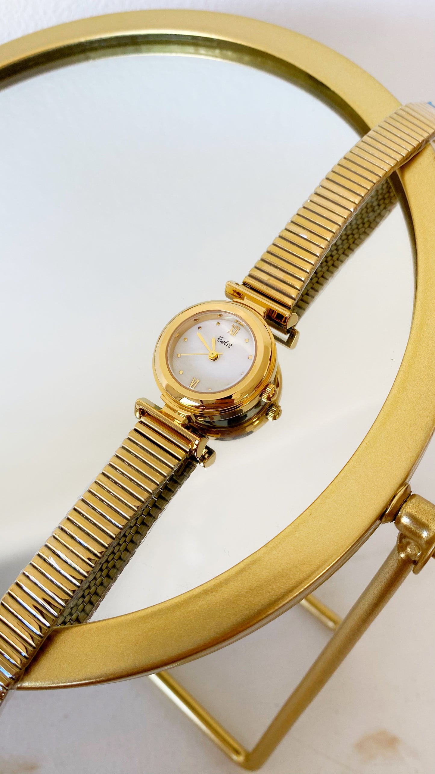 Reloj redondo dorado con nácar