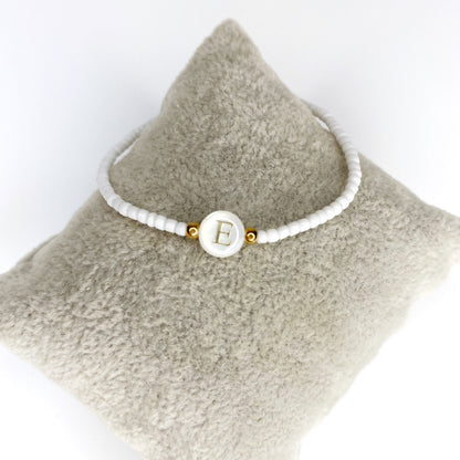 Pulsera de iniciales doradas con mostacillas blancas