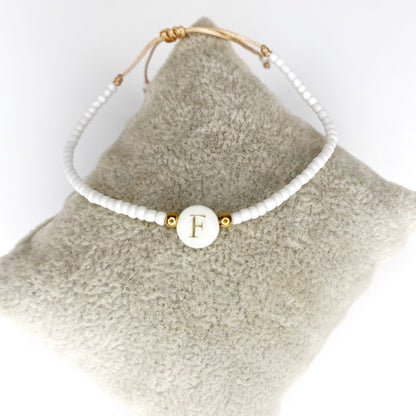 Pulsera de iniciales doradas con mostacillas blancas