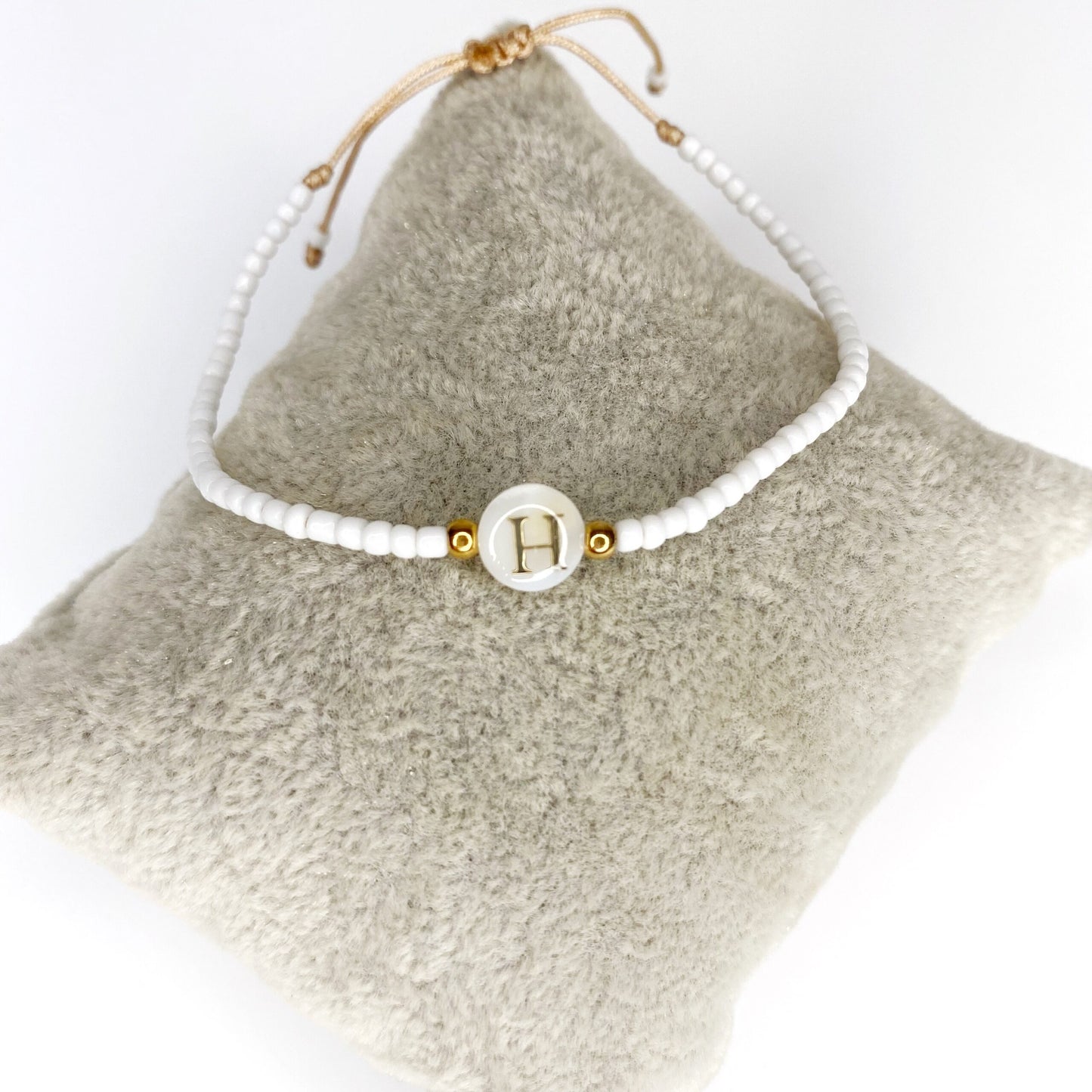 Pulsera de iniciales doradas con mostacillas blancas