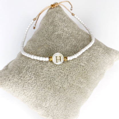 Pulsera de iniciales doradas con mostacillas blancas