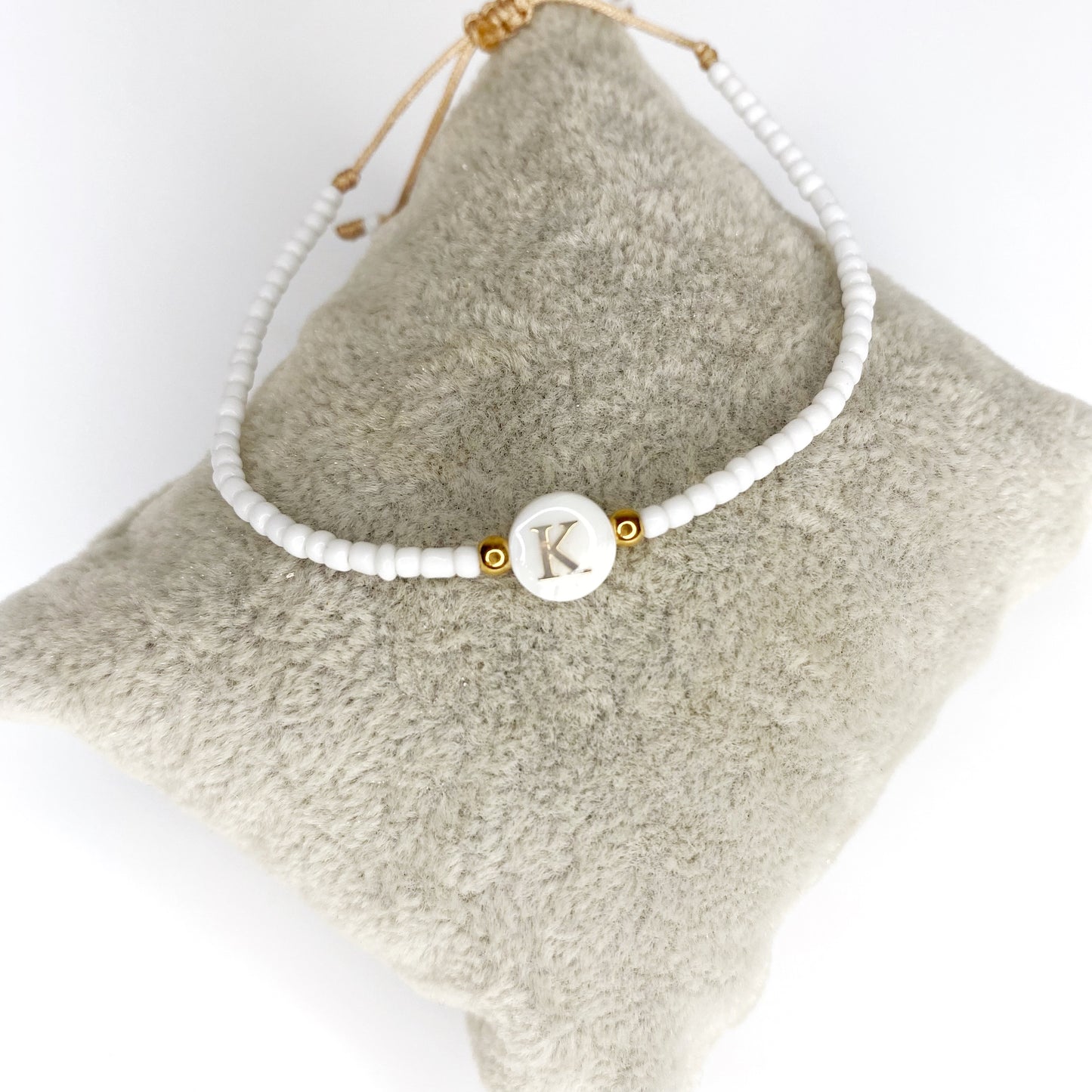 Pulsera de iniciales doradas con mostacillas blancas