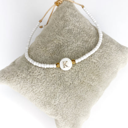Pulsera de iniciales doradas con mostacillas blancas
