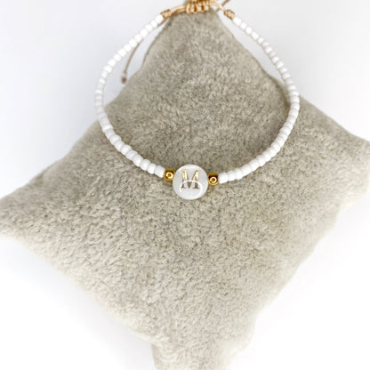 Pulsera de iniciales doradas con mostacillas blancas