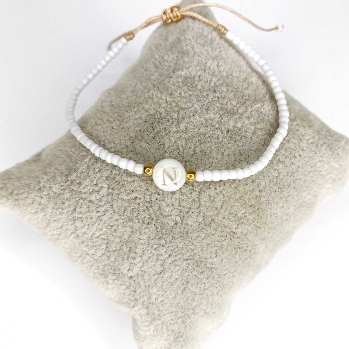 Pulsera de iniciales doradas con mostacillas blancas