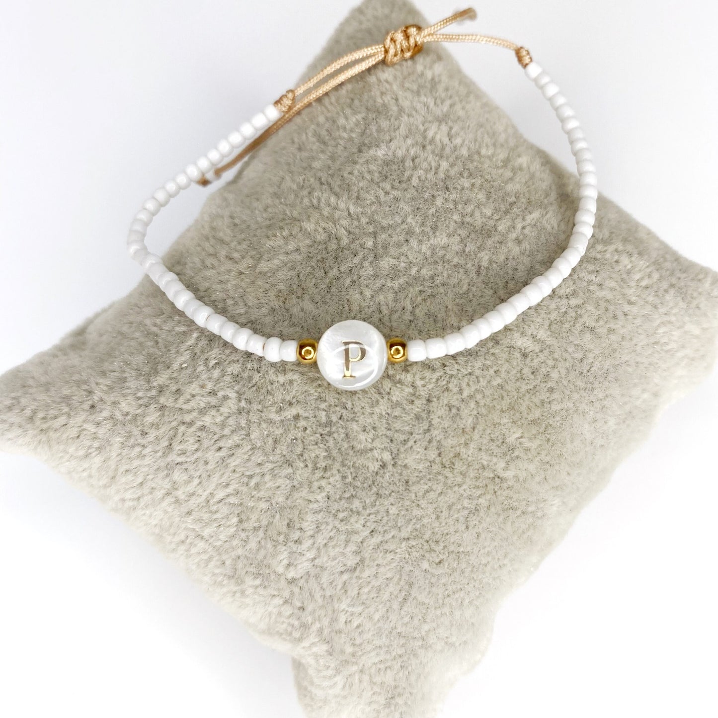 Pulsera de iniciales doradas con mostacillas blancas