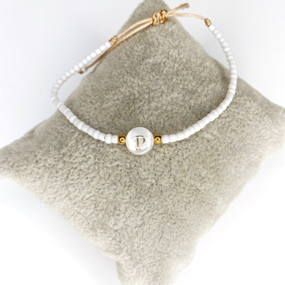 Pulsera de iniciales doradas con mostacillas blancas