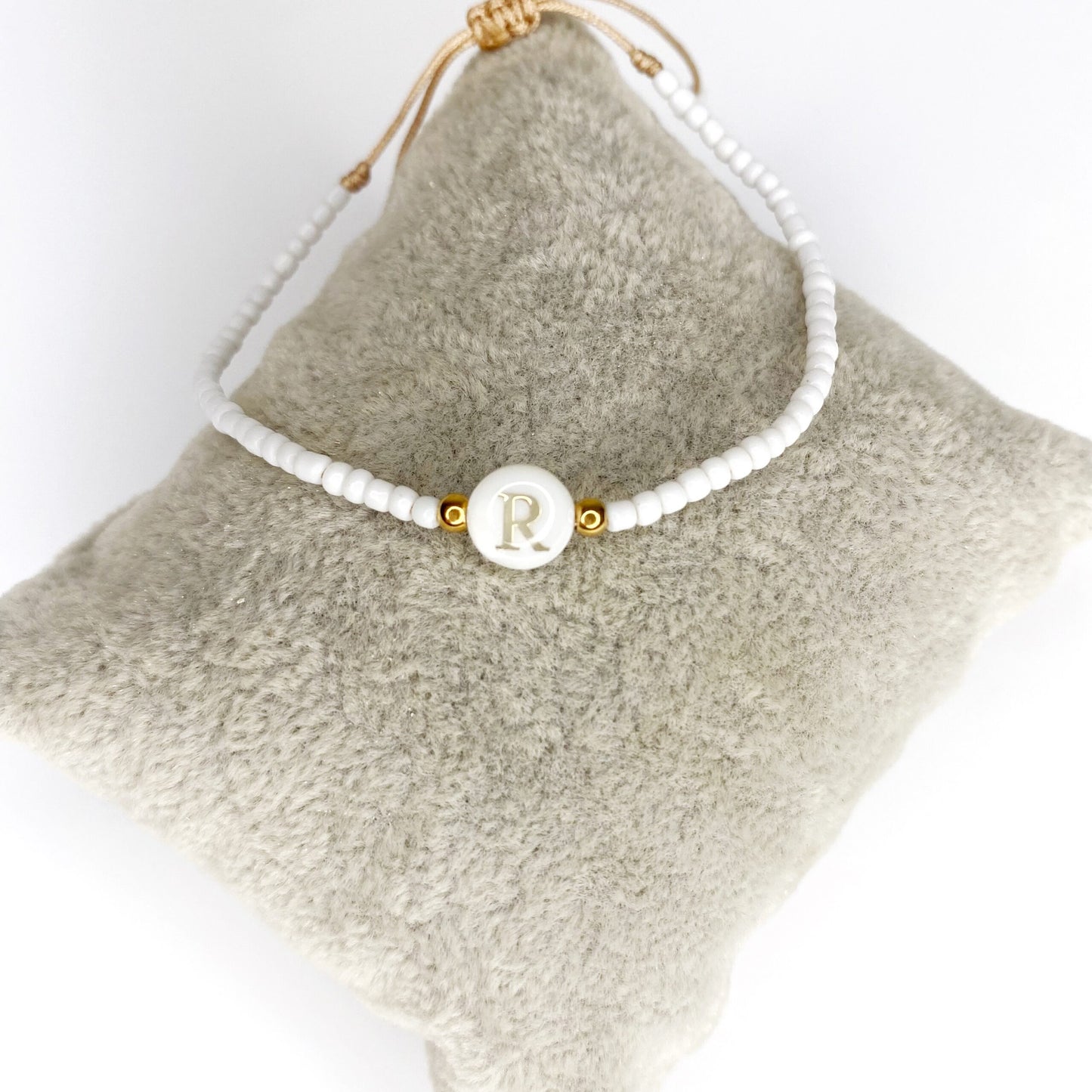 Pulsera de iniciales doradas con mostacillas blancas