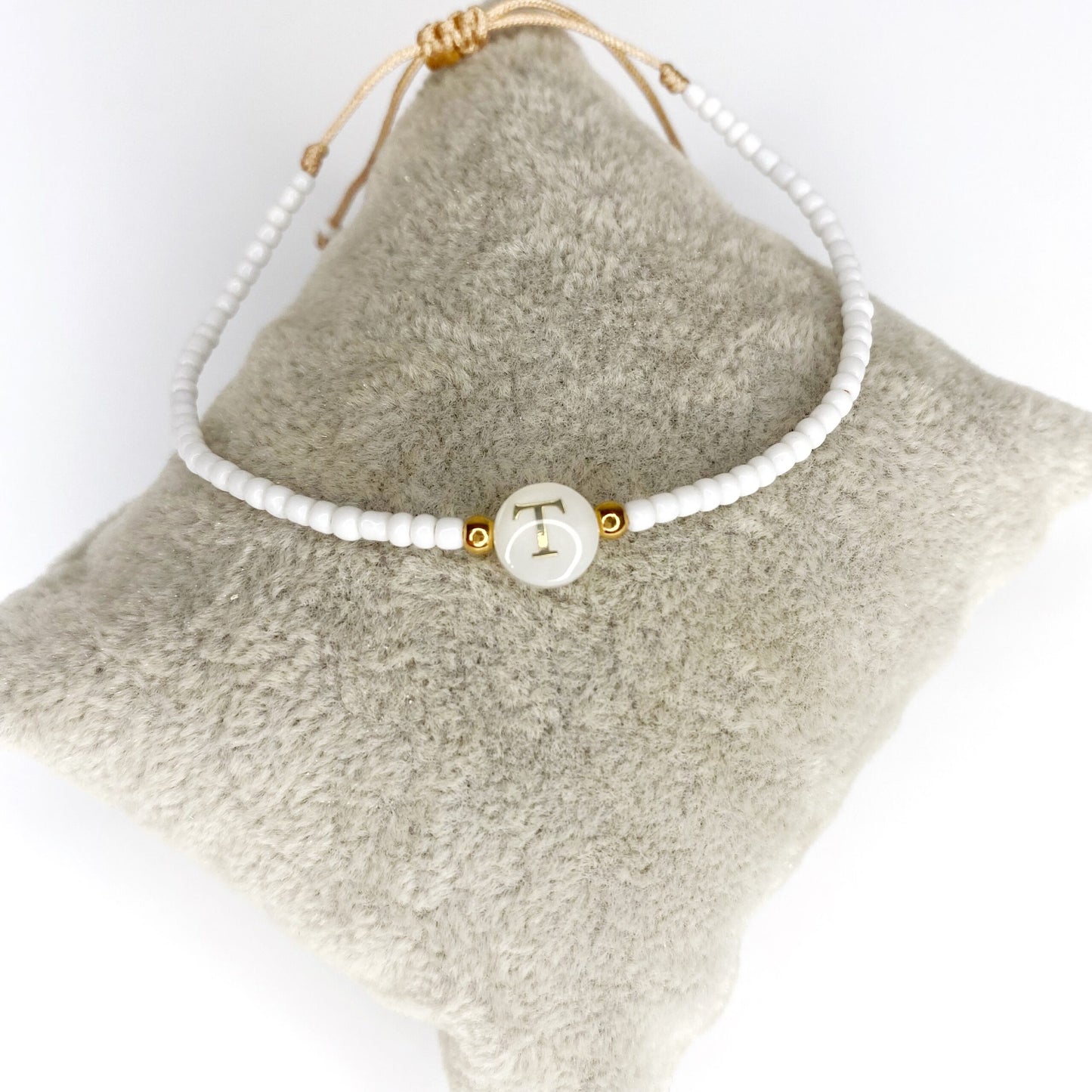 Pulsera de iniciales doradas con mostacillas blancas