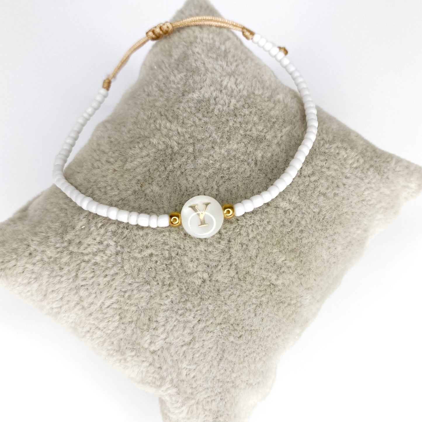 Pulsera de iniciales doradas con mostacillas blancas